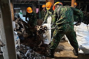 職能力量在清理曙光公司大火後的廢墟並噴灑消毒周圍環境。（圖源：VOV）