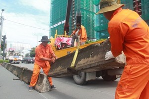 職能機關在平盛郡奠邊府-阮文商街口關閉奠邊府街分隔欄通口。（圖源：孟豐）