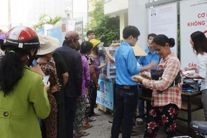 窮人排隊等待領取慈善百貨攤位的免費生活用品。