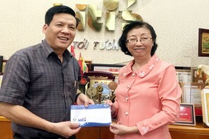 平仙公司副總經理陳芳珍(右)把贈報款項轉交給本報主編阮玉英(紅藍)。