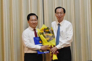 市人委會常務副主席黎清廉向黃松同志（左）頒授人事委任《決定》並送鮮花祝賀。（圖源：天理）