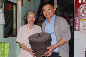 陳麗英老師（左）把放在家裡逾80年歷史的木製飯桶贈送給麒麟（右）。