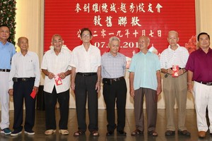 胡百全會長(左一)與丁文森副會長(右一) 向高齡校友贈送祝壽利是。