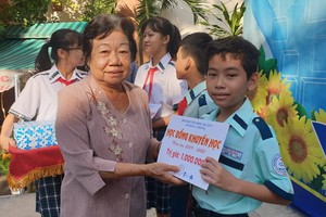 第五郡勵學會主席李金梅向李鋒中學清貧優秀生頒發助學金。