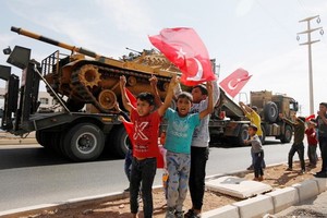 土坦克向敘邊境挺進，一些小孩子舉著土耳其國旗歡呼。（圖源：路透社）