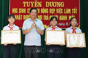 河內市教育與培訓廳副廳長范春進向三名拾遺不昧學生頒發獎狀。（圖源：越通社）