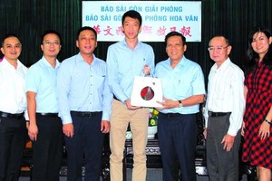 南航胡志明市營業部新任總經理步然（左四）向本報領導贈送紀念品。