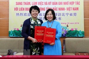 北寧省勞動聯團副主席阮氏雲霞（右）與中國浙江省總工會副主席張衛華簽署對外關係合作備忘錄。（圖源：越通社）