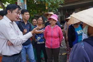 新平郡人委會副主席黎清平（左一）在職時與當地民眾交談。（圖源：嘉明）