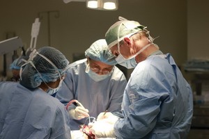 美國專家麥凱‧麥金農與手術團隊在為一名病童進行腫瘤切除手術。（圖源：FV 醫院）