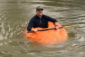 預祝萬聖節，美國田納西州克里夫蘭市一名農夫出手變910磅巨型南瓜做獨木舟，並在小溪中乘坐。（圖源：互聯網）