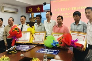 市人委會常務副主席黎清廉（右四）向貨輪沉沒救援組頒發獎金。（圖源：文平）