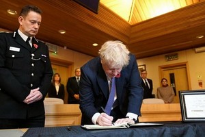 英首相在瑟羅克理事會辦公室吊唁簿上留言。（圖源：路透社）