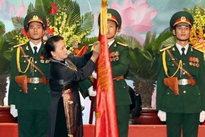 國會主席阮氏金銀向在抗美戰爭幫助老撾革命並取得特別出色成績的越南志願軍和專家頒授人民武裝力量英雄稱號。（圖源：越通社）