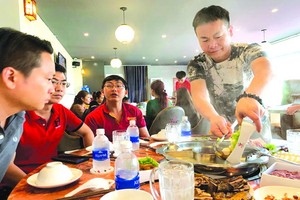 源味火鍋店老闆董先生親自為食客服務。