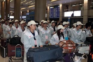 越南勞工在機場候機大廳等待航班赴韓工作。（圖源：田升）