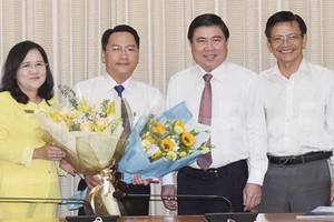 市人委會主席阮成鋒（右二）向阮晉發同志（左二）頒發人事委任《決定》。（圖源：庭理）