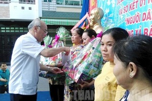 市委常務委員、宣教處主任潘阮如奎（左）向新富郡新山二坊第五街區貧困戶贈送禮物。（圖源：市黨部新聞網）