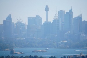 當地時間11月11日，澳大利亞新南威爾士州，一艘渡輪從悉尼煙霧繚繞的中央商務區經過。（圖源：互聯網）