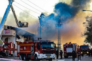 在以色列斯代羅特，消防人員為一座遭火箭彈襲擊後起火的工廠滅火。（圖源：互聯網）