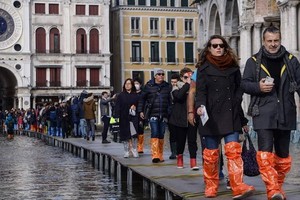 意大利著名水上城市威尼斯遭受50年來最嚴重的水災，整個城市幾乎都浸在水中，當地民眾與遊客出行遇到重重困難。（圖源：AFP）
