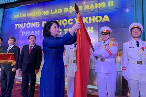 國家副主席鄧氏玉盛代表黨、國家領導向范玉石醫科大學集體和吳明春校長授予二等勞動勳章。（圖源：陳黃）