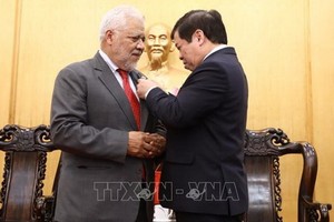 胡志明國家政治學院副院長阮曰草（右）向豪爾赫‧隆東‧烏斯卡特吉大使授予“為政治理論教育與培訓事業”紀念章。（圖源：越通社）