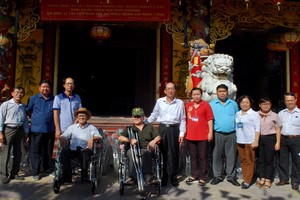 地方領導與諸位理監事向殘疾人士贈送輪椅。