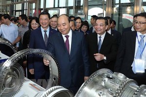 阮春福總理（前中）與代表參觀儀式上的展位。（圖源：越通社）