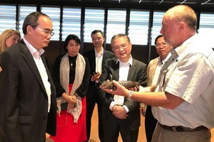 阮善仁同志（前左）參觀 Taronga 動物園，並聆聽該動物園專家介紹罕見鹹水鱷魚的特性。（圖源：喬峰）