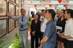 黃賢偉書畫家向各位領導、代表介紹作品。