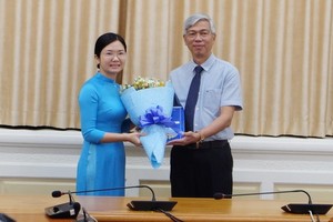 新任第六郡人委會副主席王清柳（左）從市人委會副主席武文歡手中接過人事委任《決定》和祝賀鮮花。