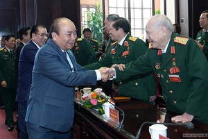 政府總理阮春福（前左）與退伍軍人交談。（圖源：Chinhphu.vn）