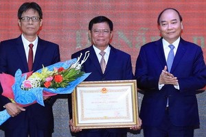 政府總理阮春福（右）向第三區域政治學院頒授一等勞動勳章。（圖源：越通社）