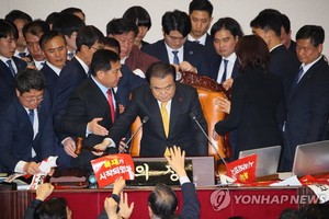 12月27日，在韓國國會，國會議長文喜相在自由韓國黨議員的阻擋下為《公職選舉法》修訂案表決結果落錘定音。（圖源：韓聯社）