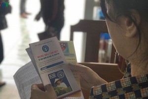 一名婦女在瞭解有關自願社保的繳費額度及相關權益資訊。（圖源：VOV）