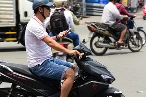 邊騎車邊拿著手機。