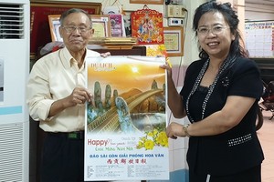 啟秀華文中心校長王沛川（左）向北京華文學院副院長劉香玲贈送本報的月曆作為紀念。