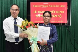 新任市委組織處副主任黎氏清翠（右）從市委書記阮善仁手中接過人事委任《決定》和祝賀鮮花。（圖源：越勇）