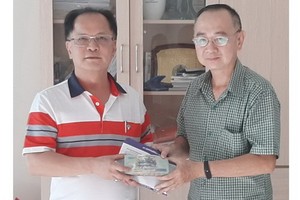 本市台商會會長鄭文忠（左）將歲暮濟貧款項交予本報編委兼編輯部主任范興代領。