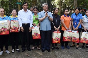 黨中央書記處常務書記陳國旺（中）向同奈省清貧勞工贈送春節禮物。（圖源：天王）