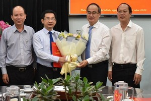 新任市委內政處主任楊玉海（左二）從市委書記阮善仁手中接過人事委任《決定》及祝賀鮮花。（圖源：豐宇）