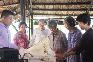 文物捐贈者在觀看劉麗英老師（右二）捐贈其母親昔日的嫁妝床簾。