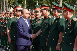 阮春福總理（前左）同第五軍區司令部幹部親切握手，互致問候。（圖源：光孝）