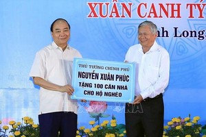 阮春福總理（左）贈送永隆省窮人100間住房。（圖源：越通社）