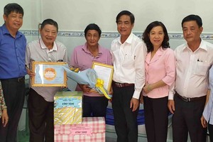 杭慰瑤董事長(左二)與吳文論書記(右三) 向貧戶移交溫情屋及春節禮物。