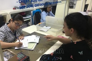 一名外籍女士前來第三郡人委會辦事處辦理行政手續。（圖源：越通社）