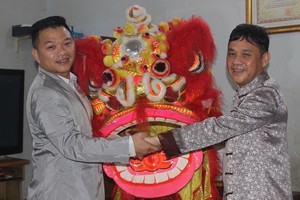 徐梓衡師傅（右）向筆者贈送一套醒獅。