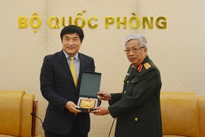 國防部副部長阮志詠上將（右）向韓國國際合作機關駐越南主任Kim Jinoh贈送紀念品。（圖源：文孝）