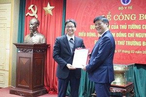 衛生部副部長阮清隆（右）從政府副總理、衛生部黨幹事處書記武德膽手中接過人事委任《決定》。（圖源：Chinhphu.vn）